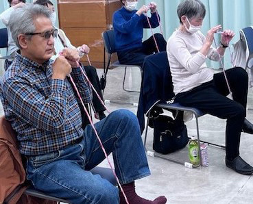 脳トレ体操・ゴムを足にかけてストレッチをしている写真です